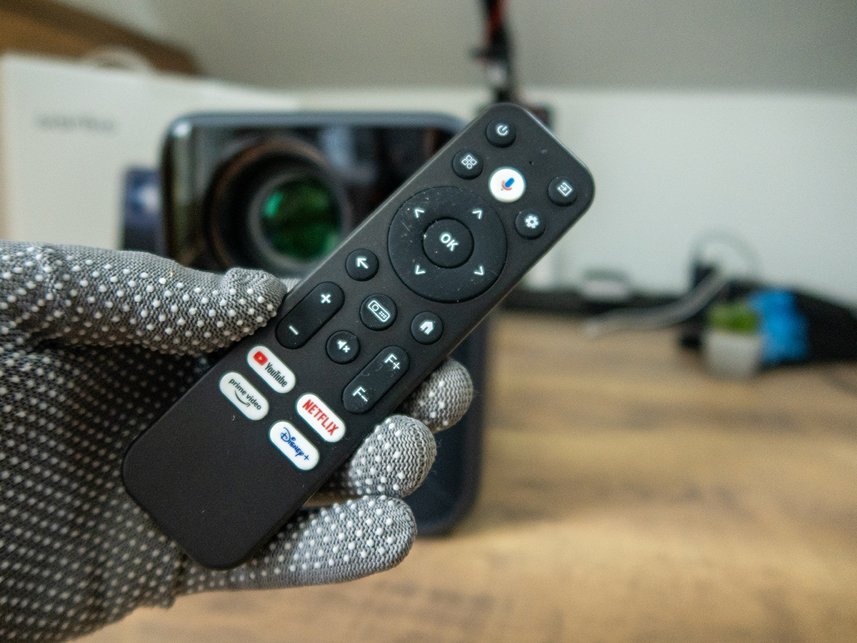 a hand holding a remote control Wanbo Mozart 1 Pro projektor teszt